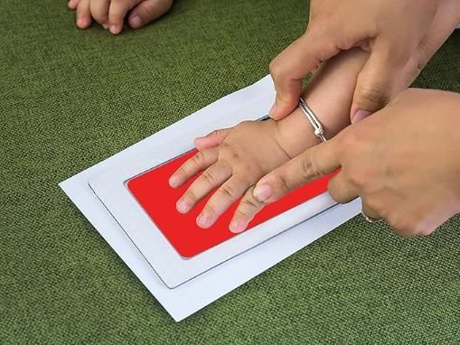 Hand pressing a red stamp on a piece of pape